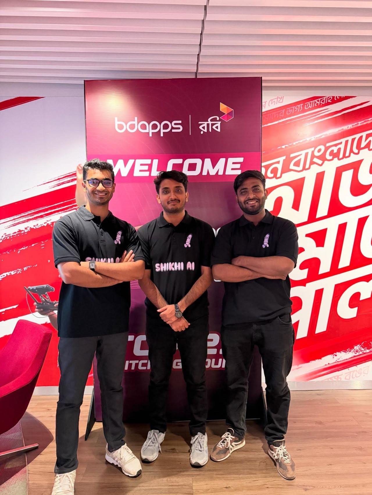 Team Shikhi AI, three members in matching black shirts, at the BDApps and Robi welcome board